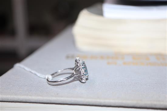 A modern 18ct white metal, aquamarine, baguette and round cut diamond set cluster ring, size K/L.